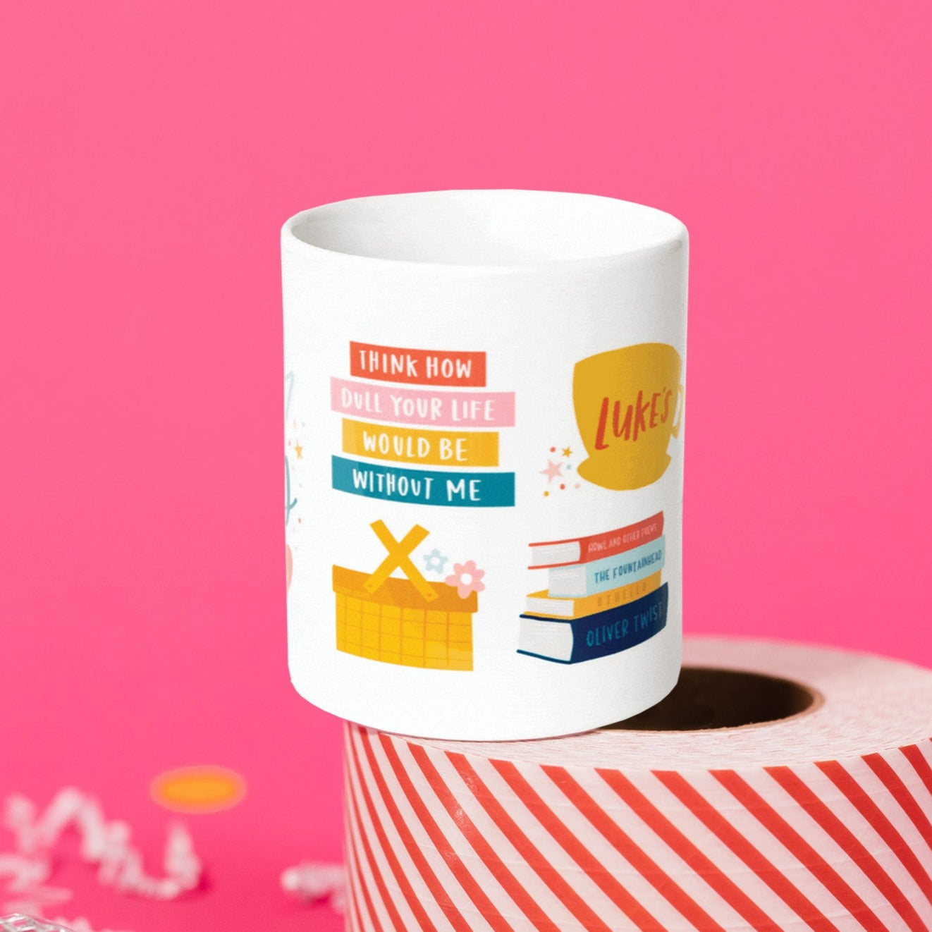 On a hot background sits a mug atop a red and white striped roll of packing tape with white crinkle and big, colorful confetti scattered around. There are mini disco balls. This Gilmore Girls inspired white mug has colorful illustrations. It has a coffee mug that says "Luke's" and there are books stacked, a picnic basket with flowers, and colorful rectangles. It says "THINK HOW”, "DULL YOUR LIFE”, "WOULD BE" and "WITHOUT ME." They are written in white, handwritten lettering.