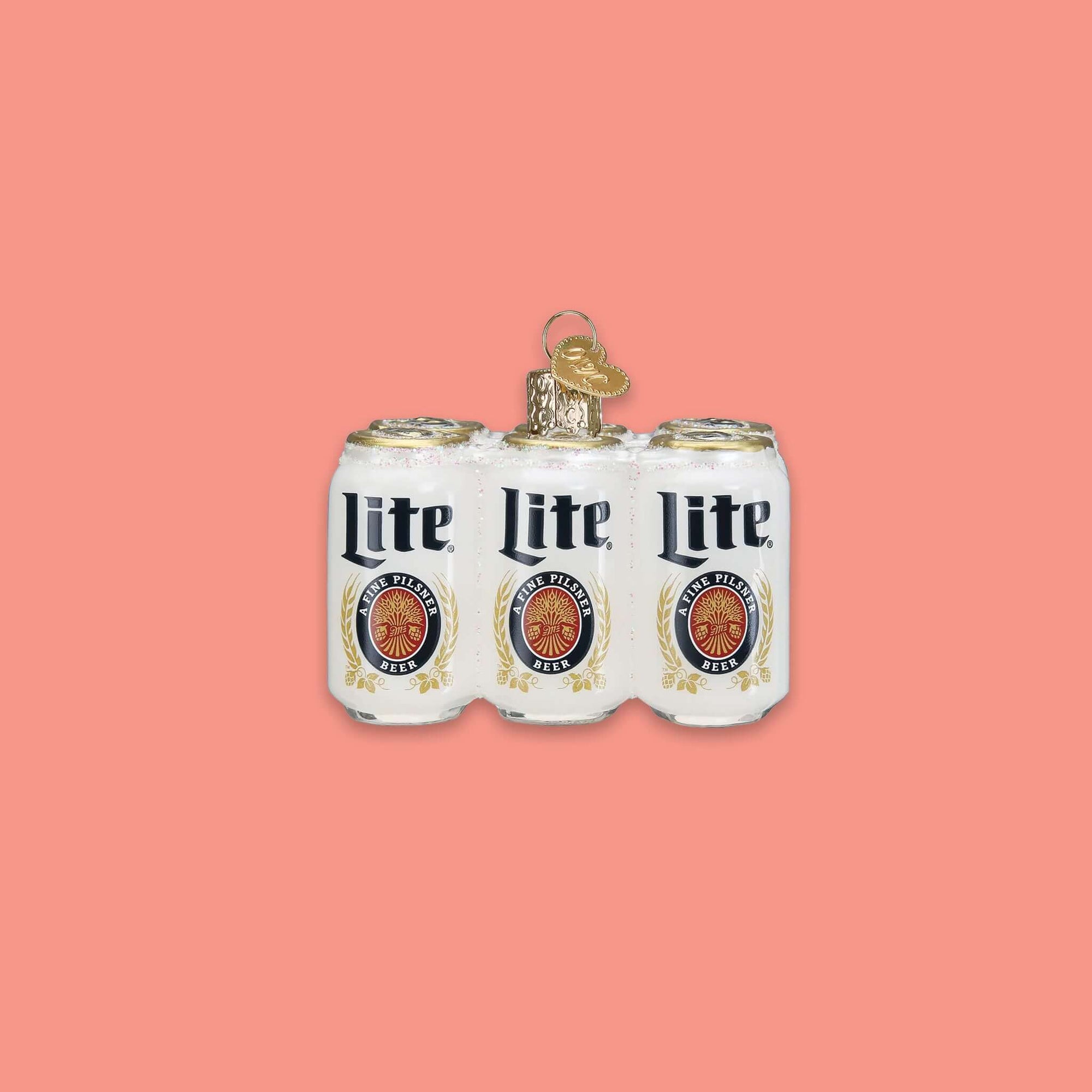 On a coral pink background sits a six pack of cans ornament. This is a glass Miller 'Lite' six pack ornament.