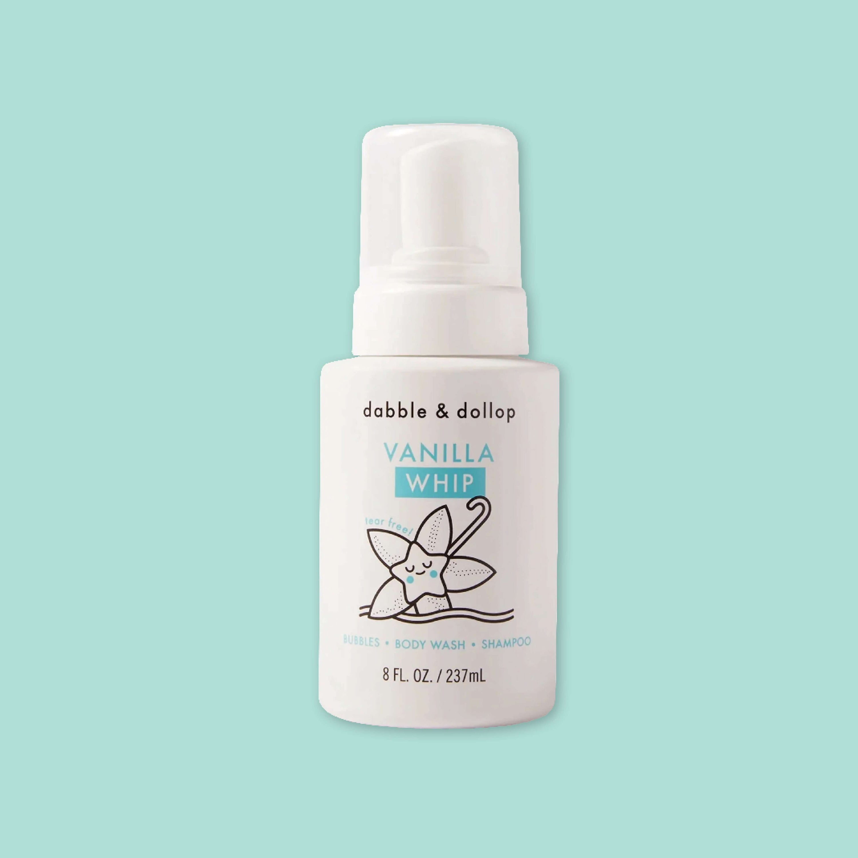 On a mint green background sits a white bottle with white cap. It has an illustration of a vanilla leaf in black. It says "dabble & dollop" in black, block font. In turquoise it says "VANILLA WHIP," "tear free!," "BUBBLES • BODY WASH • SHAMPOO." 8 FL. OZ. / 237mL
