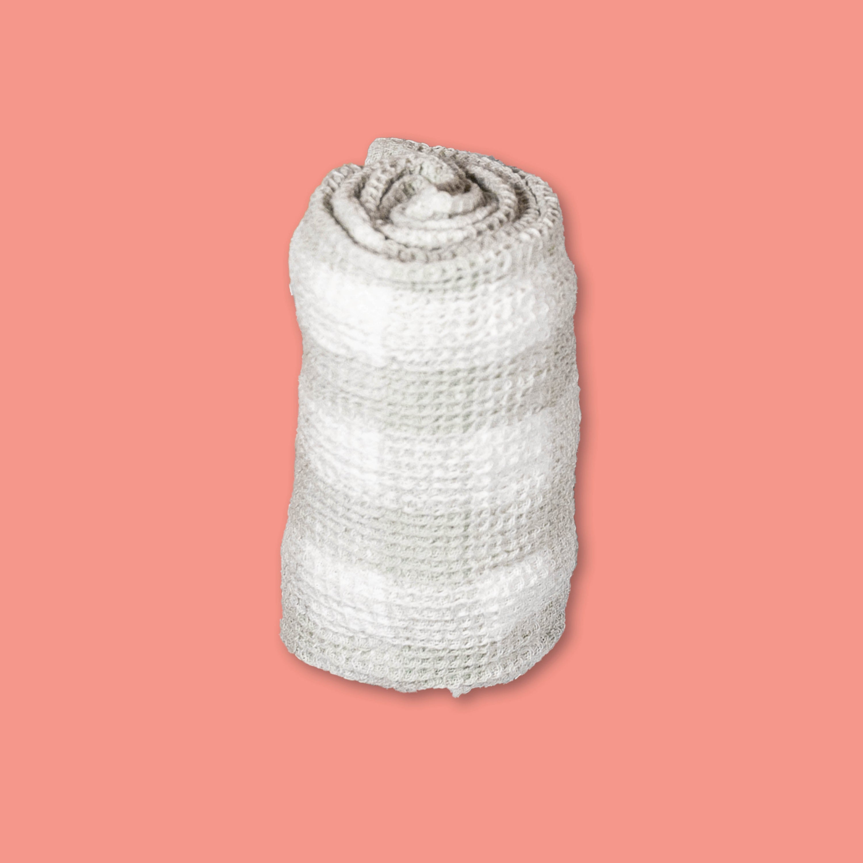 On a coral background sits a striped rolled up tea towel.