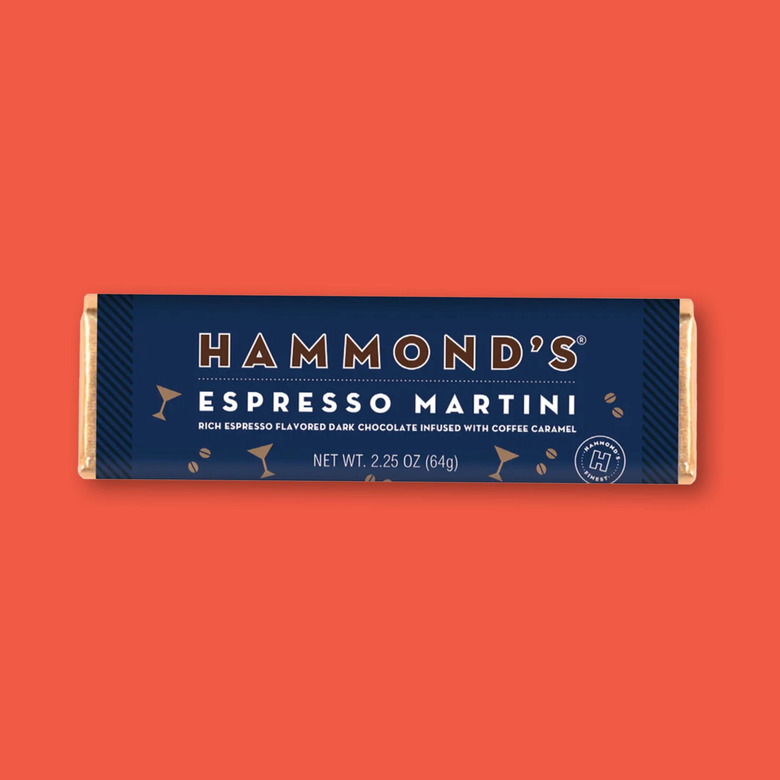 On a tomato red background sits a 2.25 oz Espresso Martini Dark Chocolate Bar with a navy blue wrapper and gold foil from Hammond's.