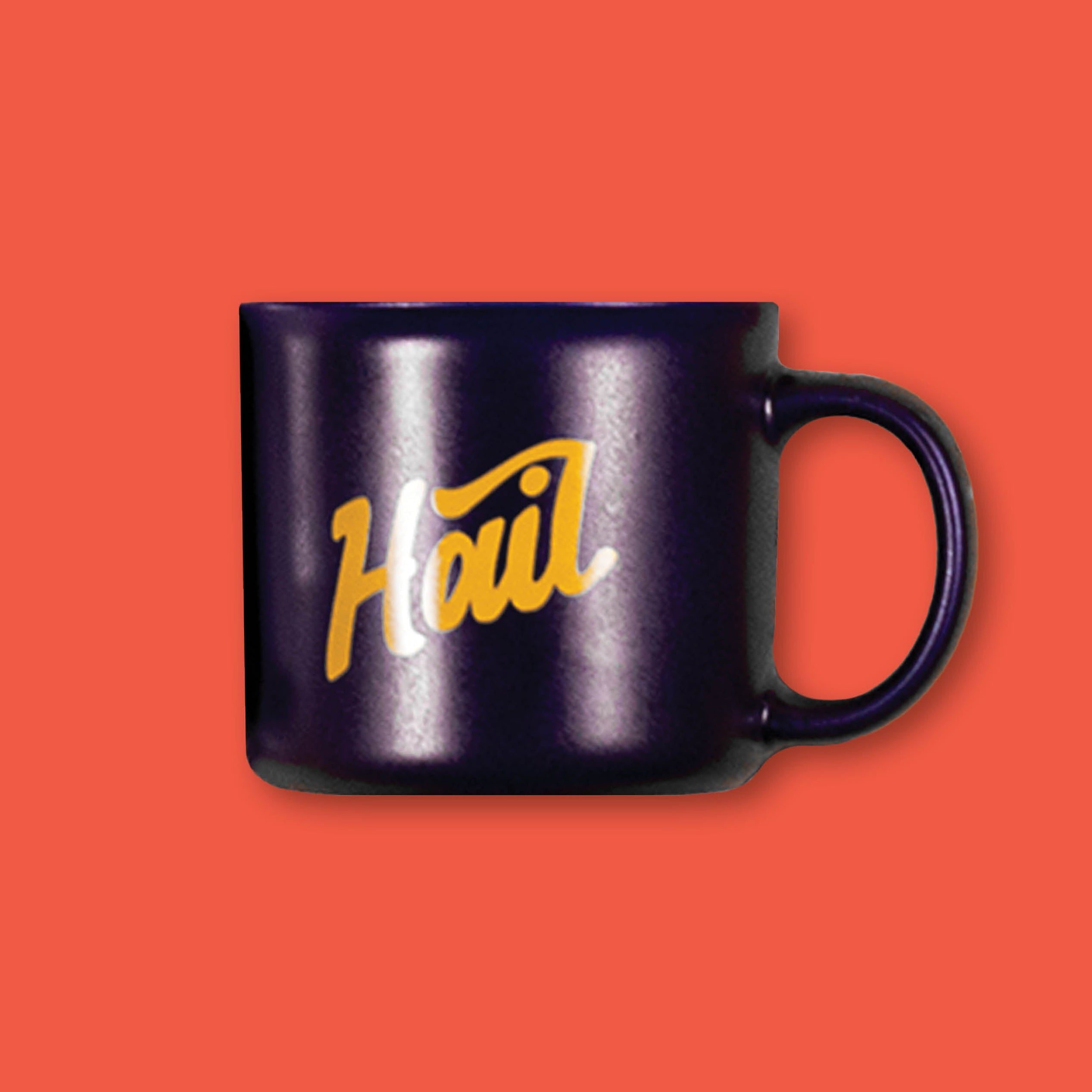 On a tomato red background sits a dark navy blue 15 oz. mug that says "Hail" in dark yellow script.
