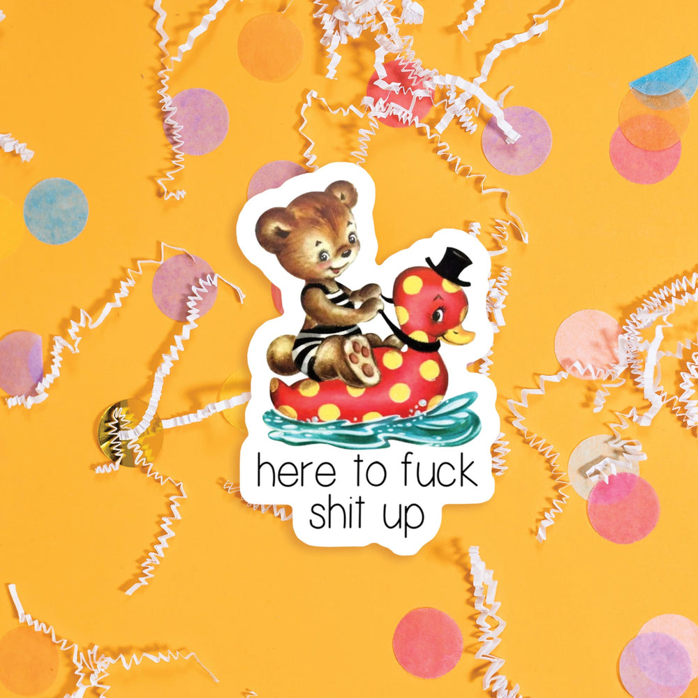On a sunny mustard background sits a sticker with colorful confetti and white crinkle scattered around. This vintage sticker has an illustration of a cute brown bear sitting on a red rubber ducky floatie with yellow dots. The ducky has a black top hat on and the bear has a vintage black and white striped swimsuit on. It says "here to fuck shit up" in black, handdwritten skinny lettering. Approximately 3".
