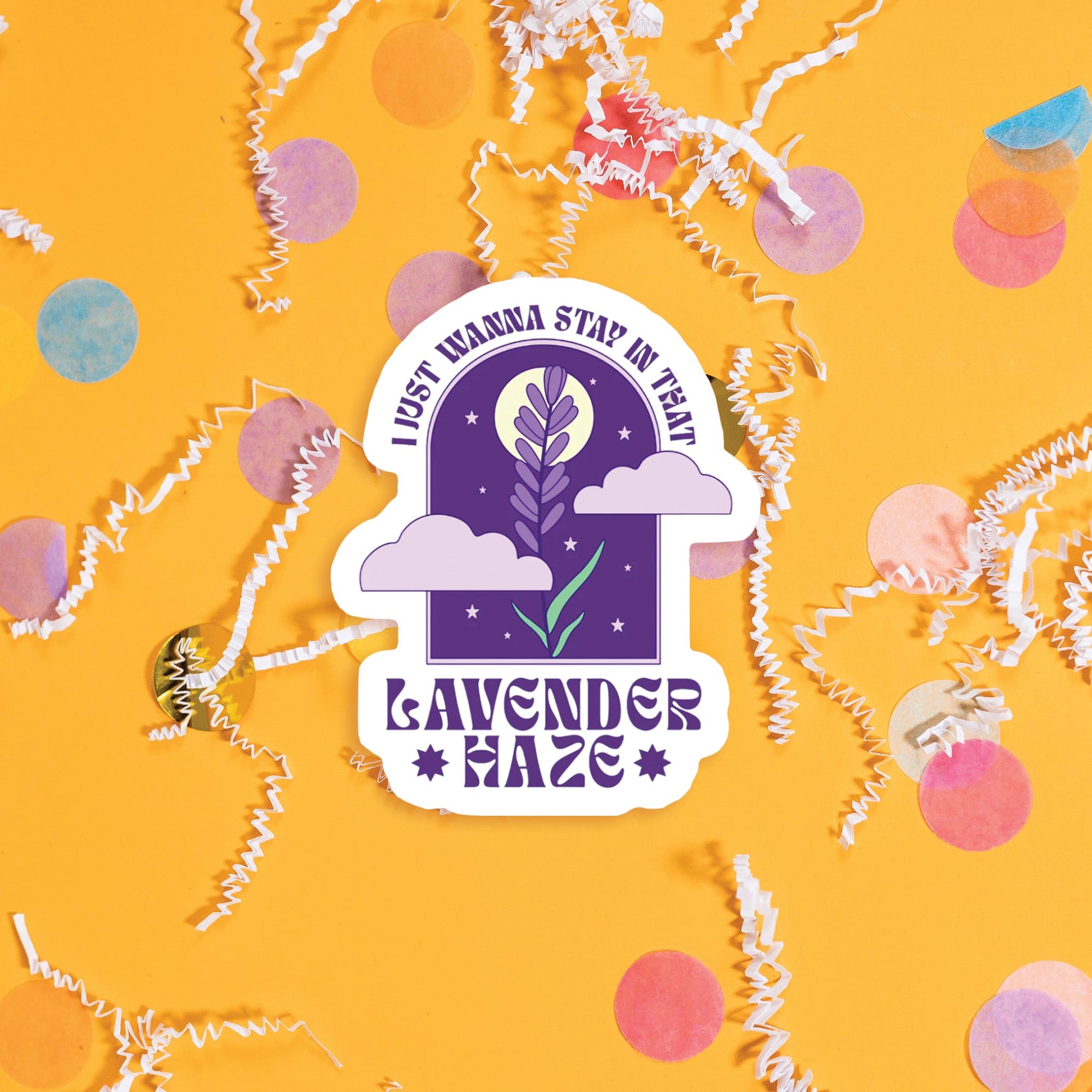 On a sunny mustard background sits a sticker with colorful confetti and white crinkle scattered around. This vintage sticker has an illustration of a purple lavender with a moon, stars and lavender clouds. At the top it says "I JUST WANNA STAY IN THAT" and the bottom it says "LAVENDER *HAZE*." It is in a purple, all caps funky lettering. Approximately 3".