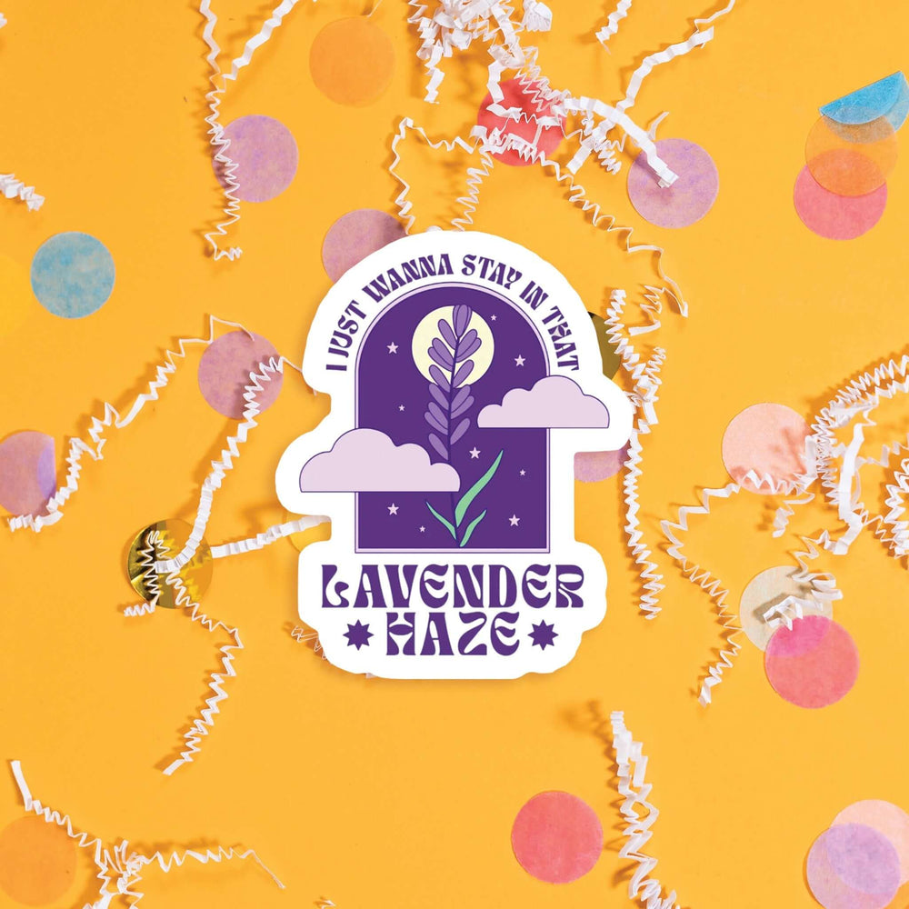 On a sunny mustard background sits a sticker with colorful confetti and white crinkle scattered around. This vintage sticker has an illustration of a purple lavender with a moon, stars and lavender clouds. At the top it says "I JUST WANNA STAY IN THAT" and the bottom it says "LAVENDER *HAZE*." It is in a purple, all caps funky lettering. Approximately 3".