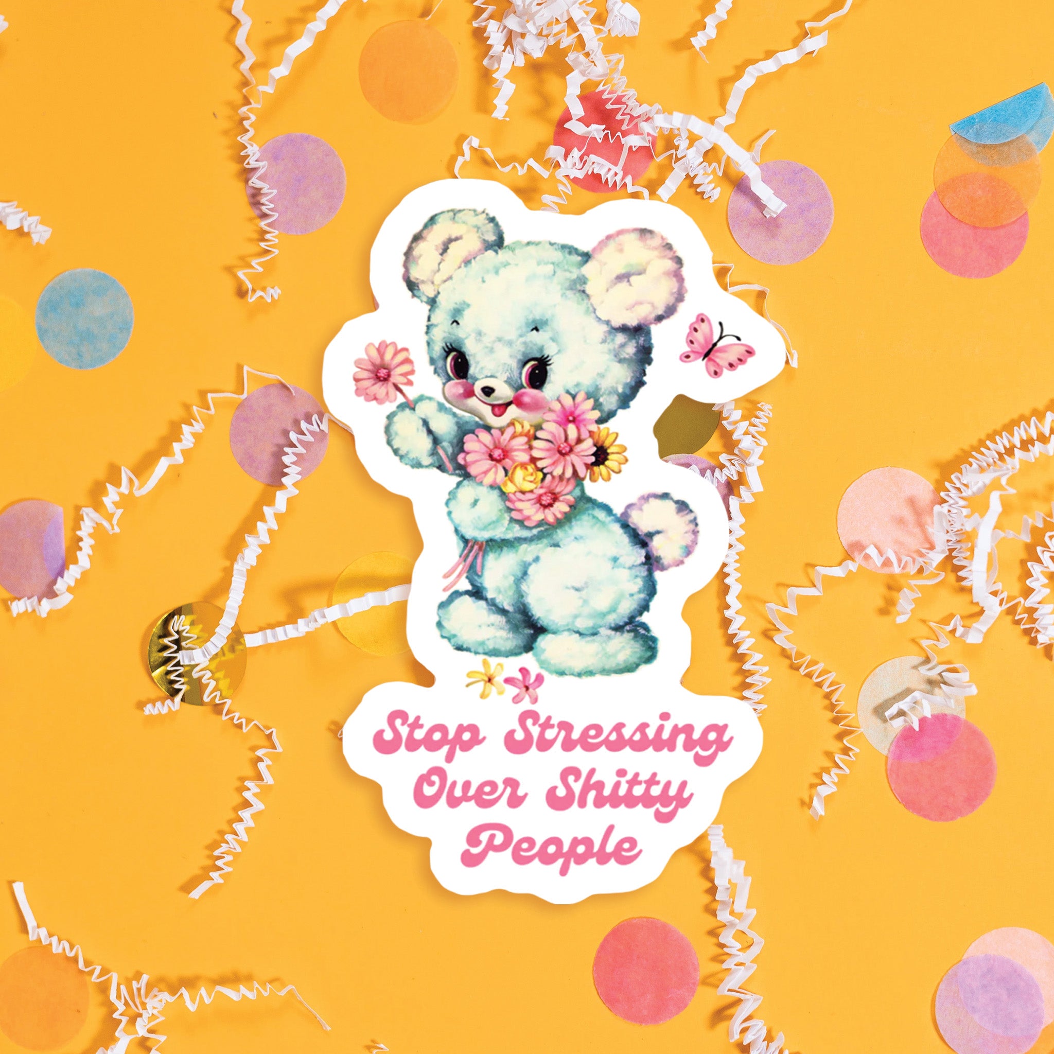 On a sunny mustard background sits a sticker with colorful confetti and white crinkle scattered around. This vintage sticker has an illustration of a cute white bear holding a bouquet of flowers. It says "Stop Stressing Over Shitty People" in bubblegum pink, handwritten script lettering. Approximately 3".