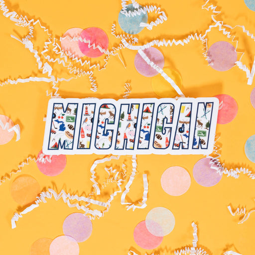 On a sunny mustard background sits a sticker with white crinkle and big, colorful confetti scattered around. This white sticker says "MICHIGAN" in a navy outline will illustrations of icons inside the word. The colorful illustrations are of Michigan favorites (Motown, Vernors, Faygo, coney dogs, the Michigan left) as well as activities, symbols, and landmarks. 3"-4"
