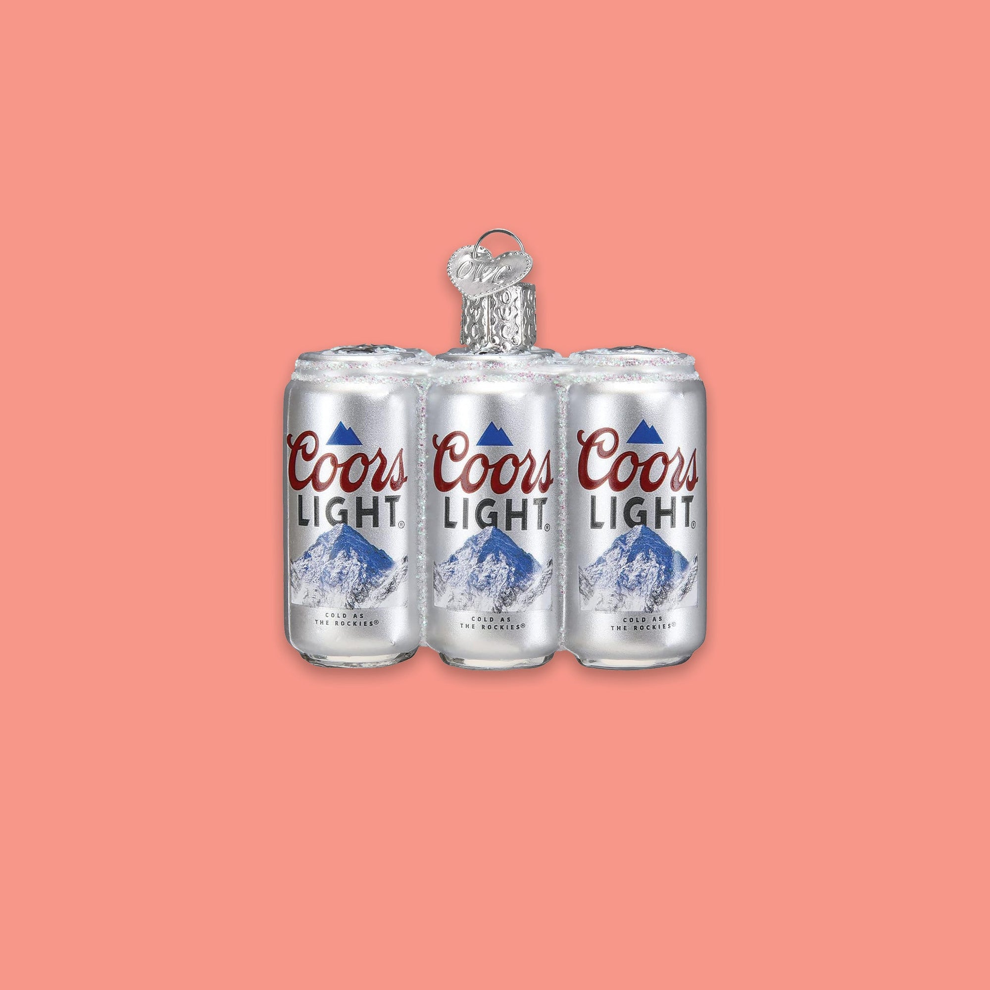 On a coral pink background sits a six pack of cans ornament. This is a glass 'Coors Light' six pack ornament.