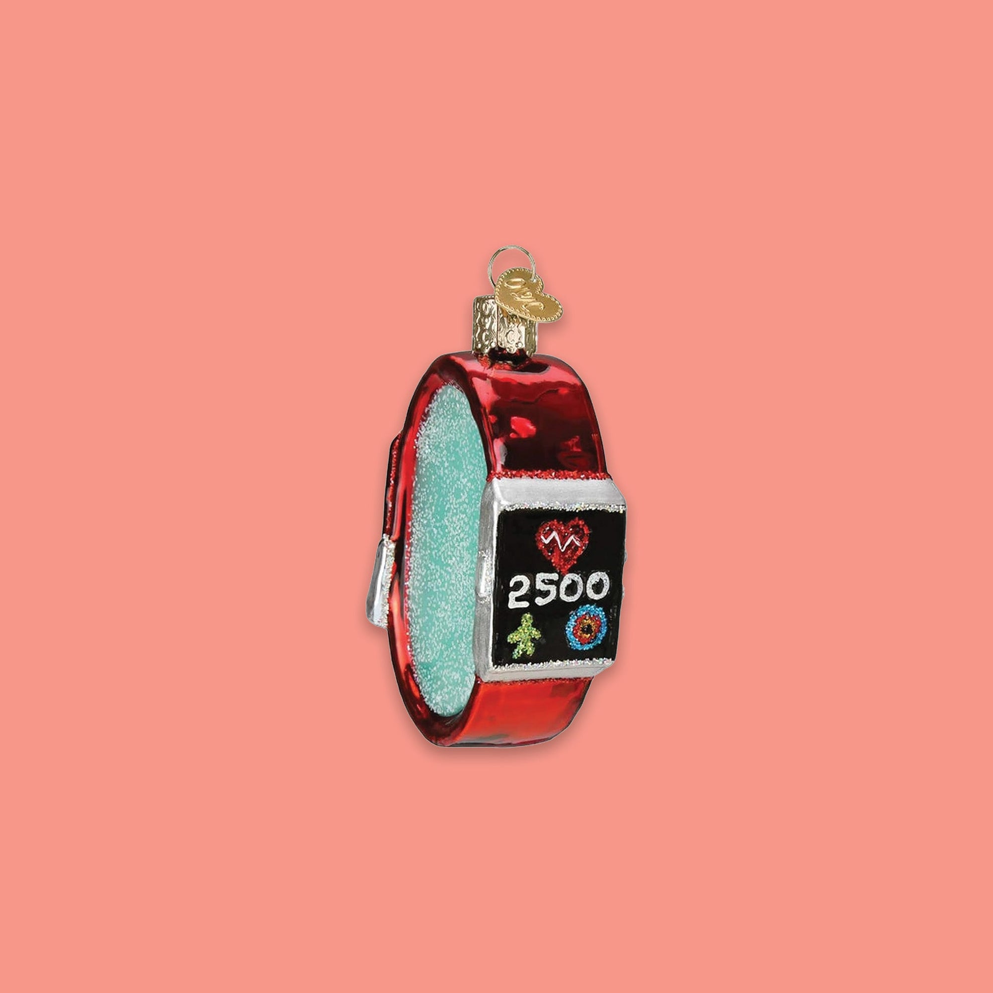 On a coral pink background sits a watch ornament. This is a glass ornament of a red fitness watch with a red heart, green person, target rings, and '2500'.