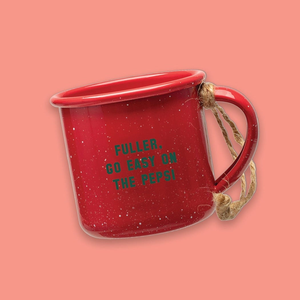 On a coral pink background sits a red mini campfire mug with white specks. It says "FULLER, GO EASY ON THE PEPSI" in green collegiate lettering. It has twine on the handle.