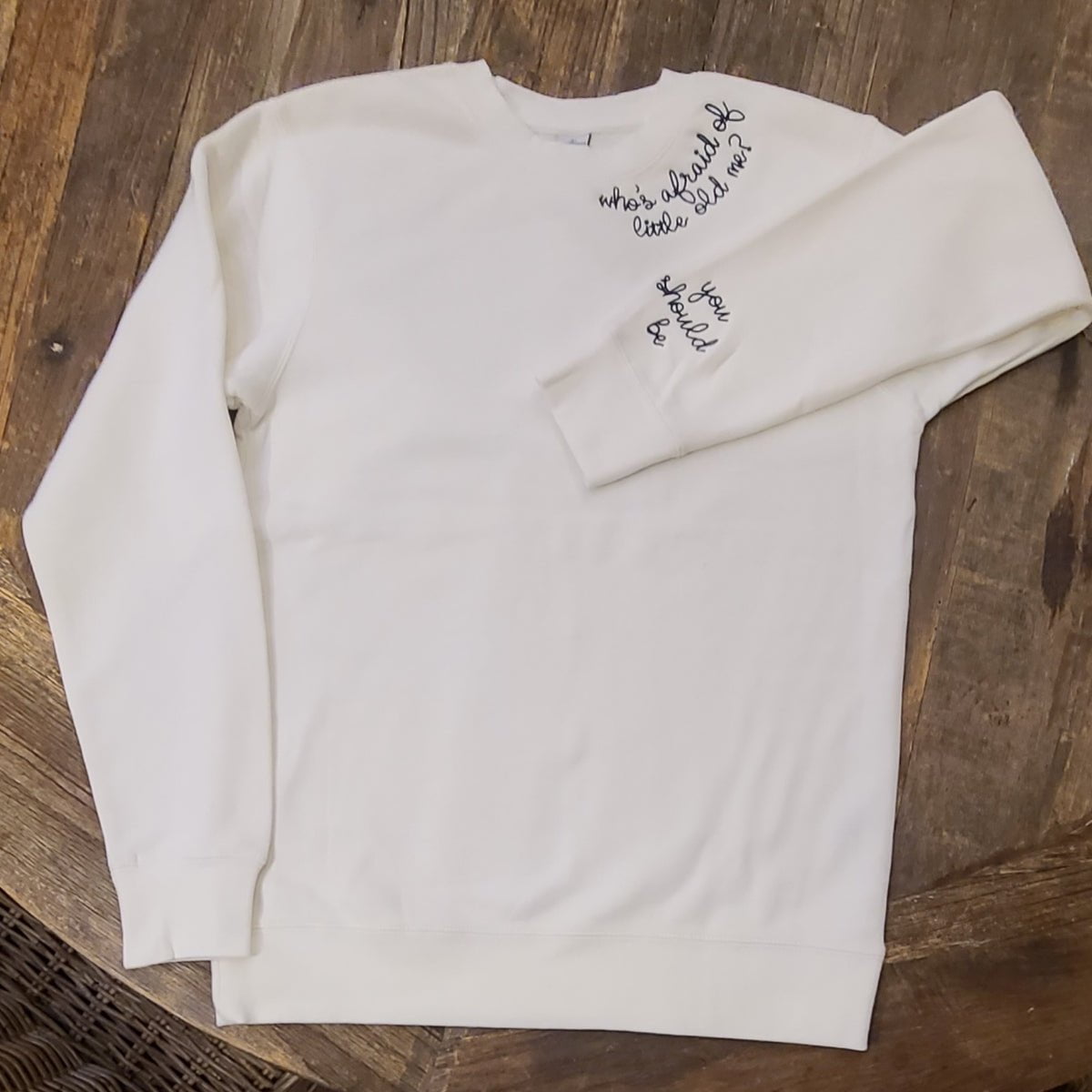 white crew neck sweatshirt embroidered with "who's afraid of little old me? You should be."