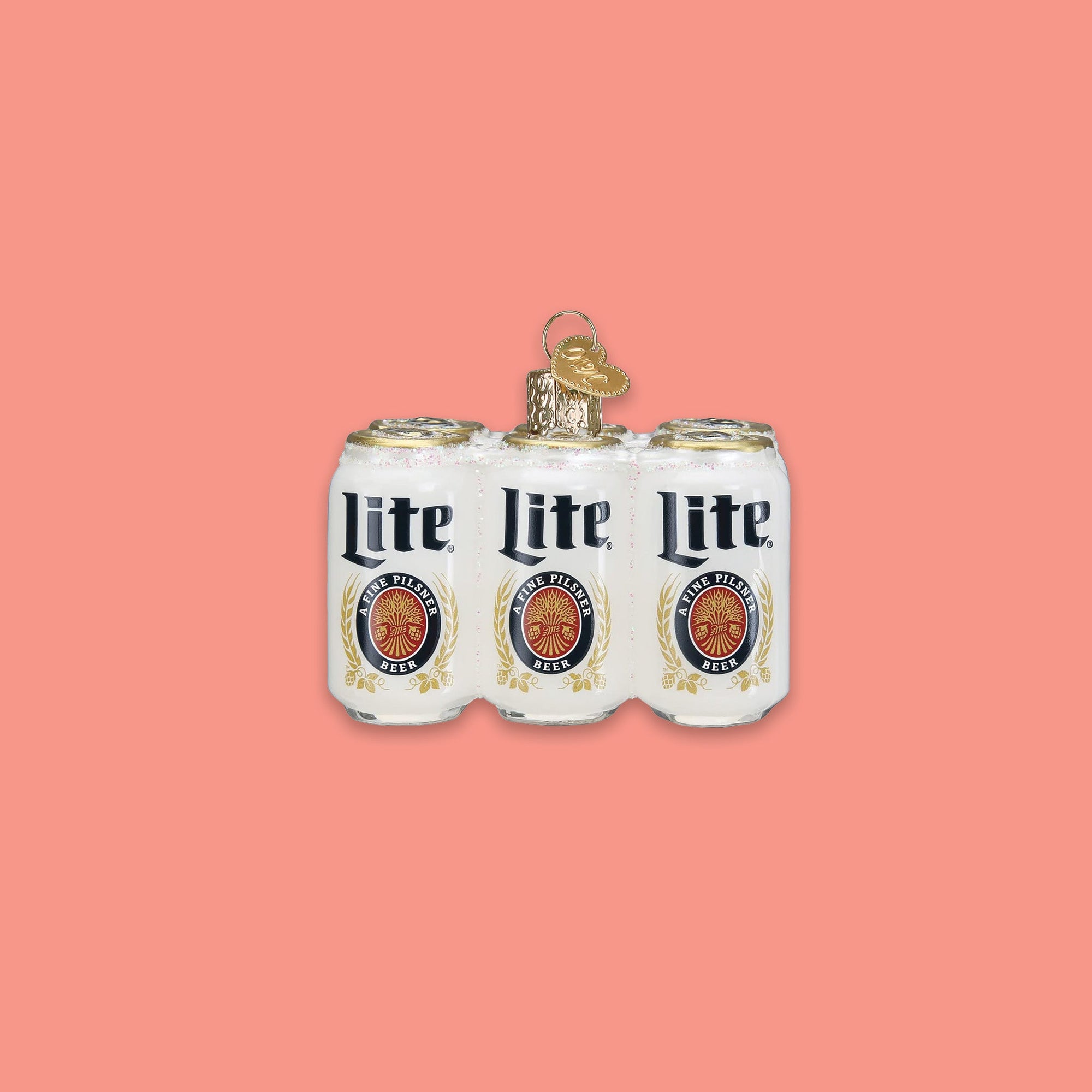 On a coral pink background sits a six pack of cans ornament. This is a glass Miller 'Lite' six pack ornament.