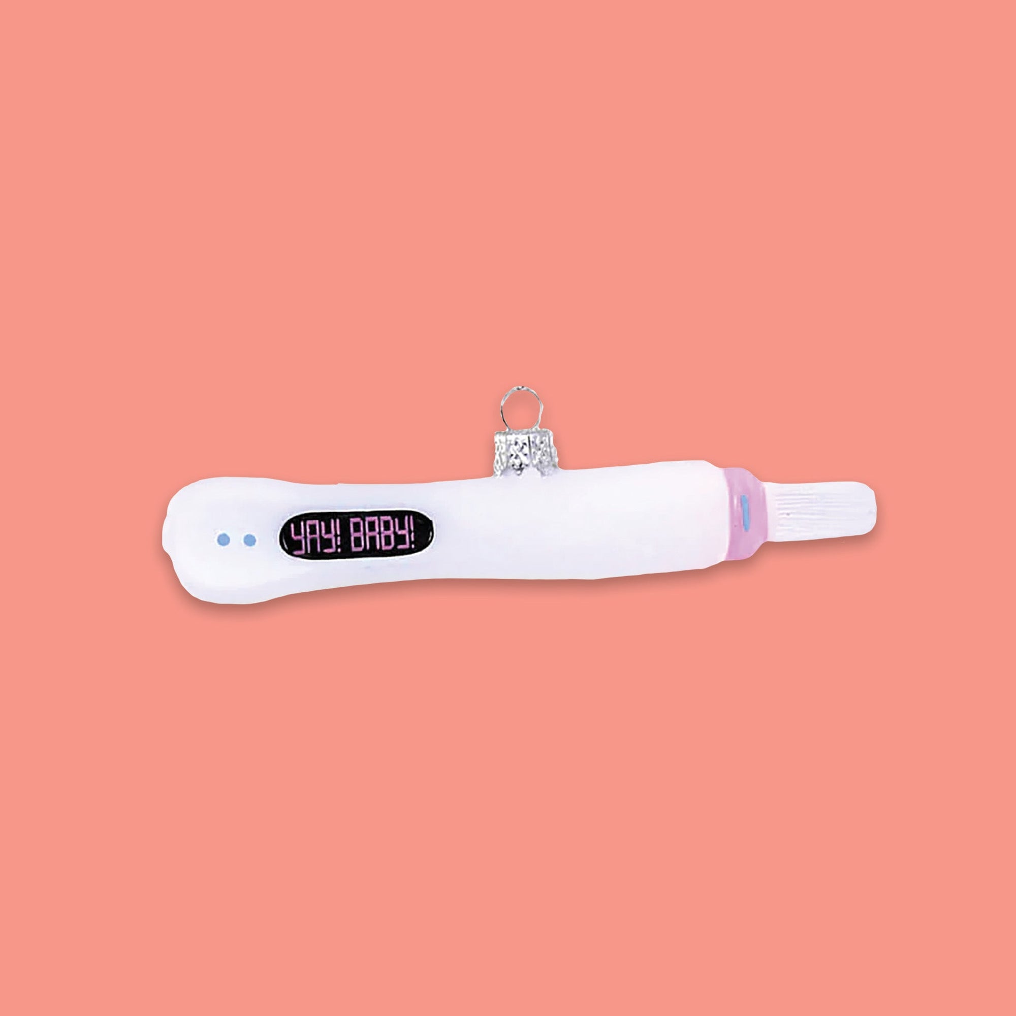 On a coral pink background sits a white pregnancy test glass ornament. It says in pink "YAY! BABY!" and there two light blue dots.