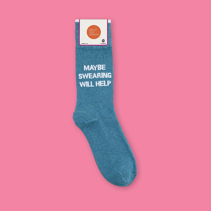 On a bubblegum pink background sits a sock. This denim blue sock says "MAYBE SWEATRING WILL HELP" in white, all caps block font. There is a white trim at the top.
