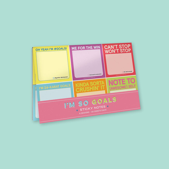 On a mint green background sits a set of six "I'M SO GOALS" colorful, sticky notes. Each one is in a different color with different sayings. The yellow one says "OH YEAH I'M #GOALS." The purple one says "ME FOR THE WIN." The red one says "CAN'T STOP WON'T STOP." The light blue one says "I'M 24-KARAT GOALS." The orange one says "KINDA SORTA CRUSHIN' IT," and the lime green one says "NOTE TO (AWESOME) SELF." There are 20 sheets each.