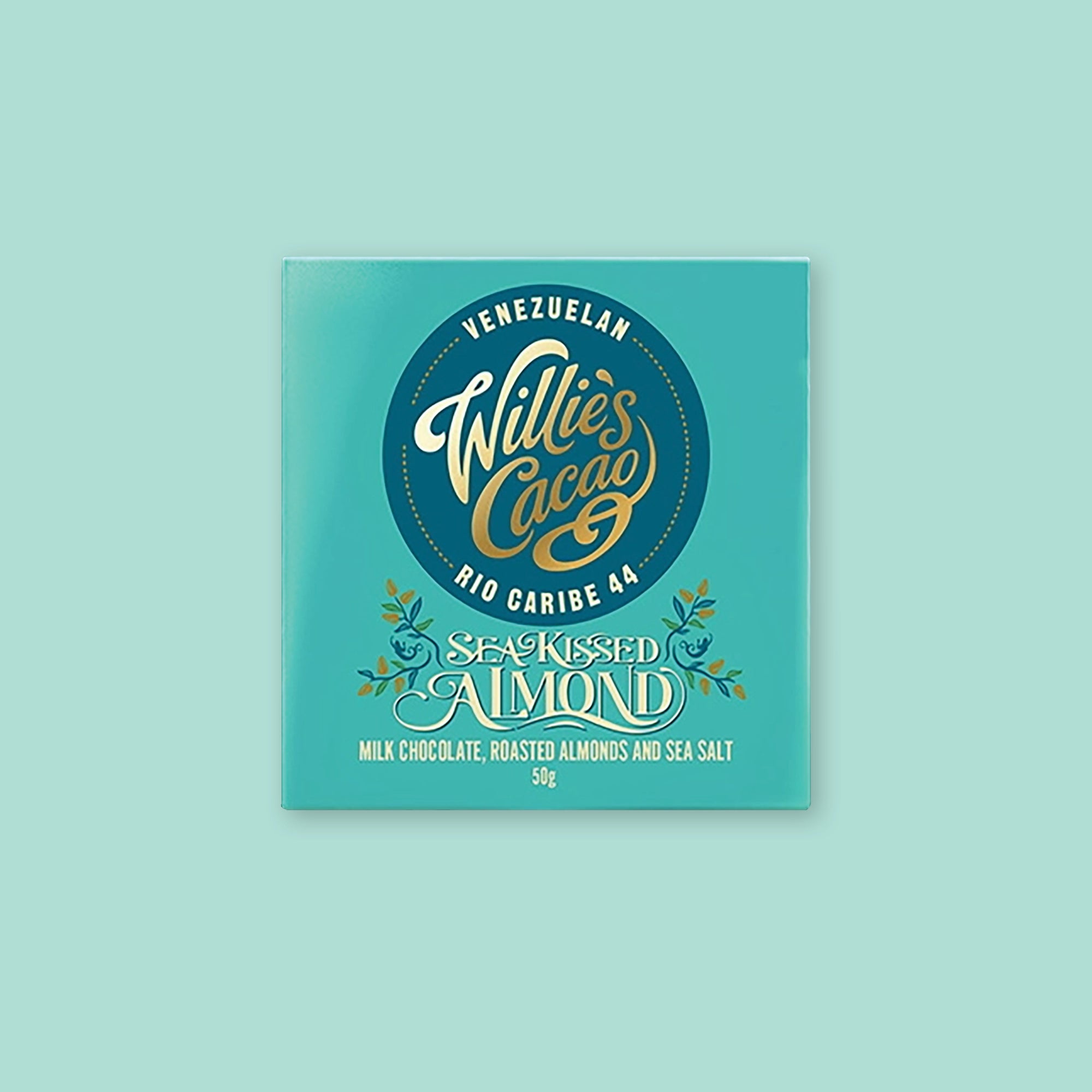 On a mint green background sits tiffany blue package. It has illustrations of almonds and leaves. It has a dark teal circle label on the front. It is Willie's Cacao Cuban Baracoa 44 "MILK CHOCOLATE, ROASTED ALMONDS AND SEA SALT." 50g