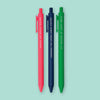 On a mint green background sits 3 retractable pens. They are hot pink, navy, and kelly green. They hot pink one says "BINGED THE WHOLE SEASON." The navy one says "ORDERED THE EXTRA LARGE COFFEE" and the kelly green one says "HIT SNOOZE AT LEAST TWICE" in white, all caps italic block font.