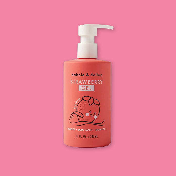 On a bubblegum pink background sits a red bottle with a white pump cap. It has a black illustrated strawberry on the front and it says "dabble & dollop" in black, block font. It is a 'STRAWBERRY GEL' and it is 'tear free!'. I also says "BUBBLES • BODY WASH • SHAMPOO" in white, all caps block font. 10 FL. OZ. / 296mL