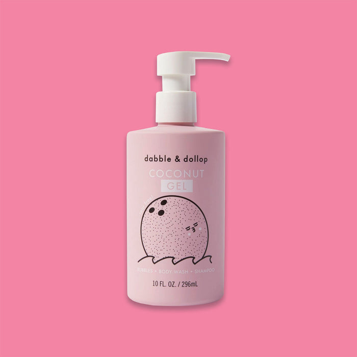 On a bubblegum pink background sits a pump bottle. This light pink bottle has a white pump top and a black illustration of a coconut and waves. It says "dabble & dollop" in black, block font. Under it says "COCONUT GEL" in white, all caps block font. Under the illustration says "BUBBLES • BODY WASH • SHAMPOO" in white, all caps block font. 10 FL. OZ. / 296mL