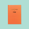 On a mint background sits a book. This orange journal says "EVERYTHING IS FINE" in gold, all caps block font.