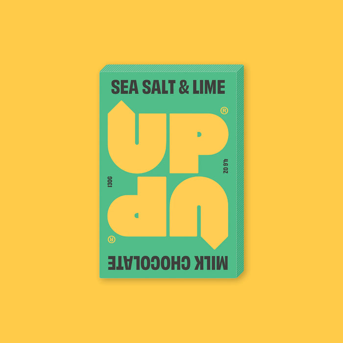 On a sunny mustard background sits a box of UP UP Sea Salt & Lime Chocolate. The packaging is in lime green and yellow. 130G 4.6 OZ