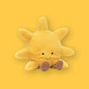 On a sunny mustard background sits an Amuseable Sun squishy. It is chubby and cuddly in buttery gold, sporting cheery cordy chocolate feet and a cute smile.