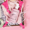 On a bubblegum pink background sits a wooden tray with a few cute pink baby products on white paper krinkle. This is a close-up featuring the pink bottle of Dabble & Dollop Coconut Gel tear-free bubble bath.