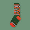 On a mossy green background sits a pair of socks. This  "Home is Where the Weed Is" retro novelty socks are a funky dark green with orange and lavender stripes.