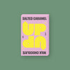 On a mossy green background sits a box of UP UP Salted Caramel Chocolate. The packaging is in light pink and yellow. 130G 4.6 OZ