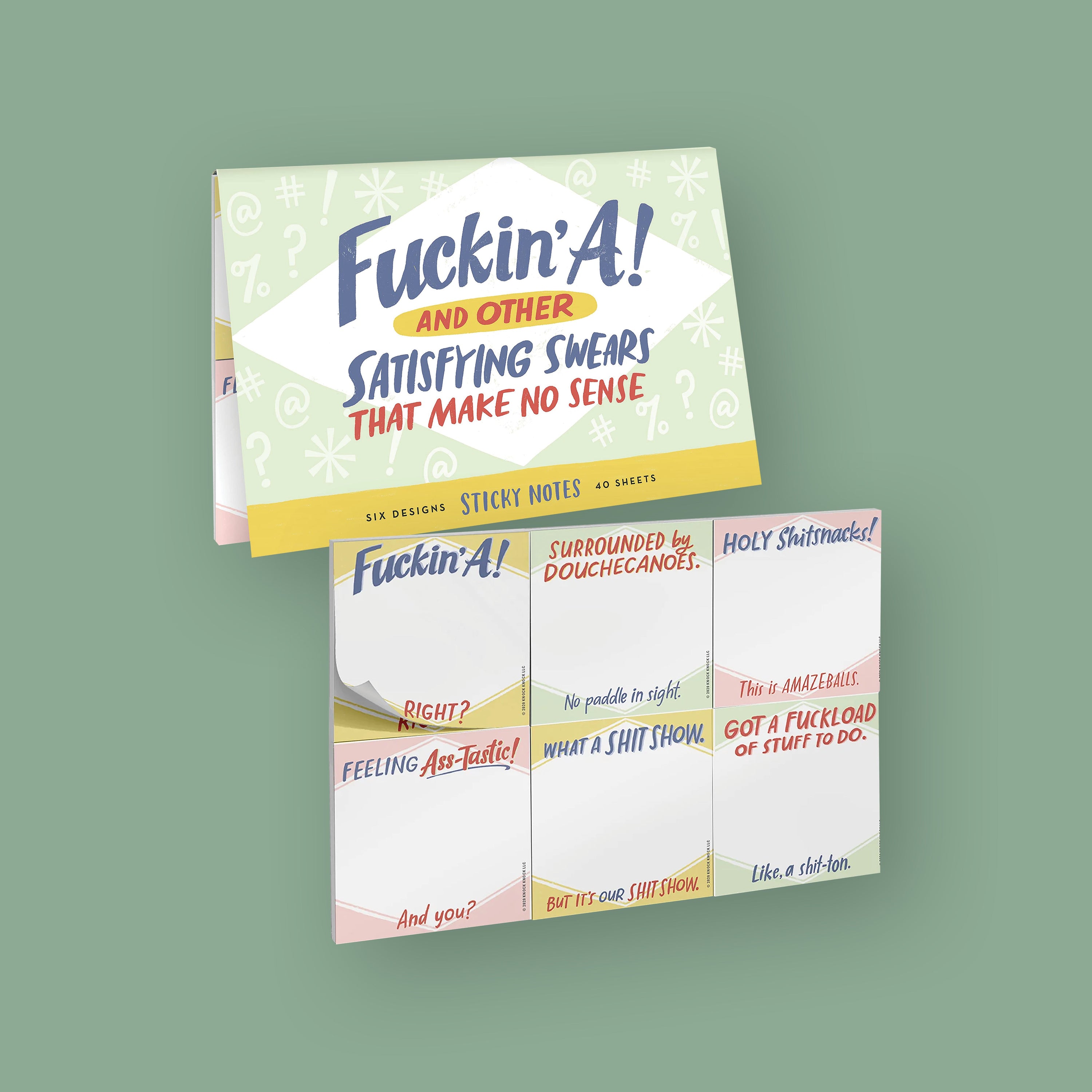 On a moss green background sits a colorful package with six different sticky notes under it. The front of the package says "Fuckin' A AND OTHER SATISFYING SWEARS THAT MAKE NO SENSE", in blue, red, and yellow handwritten lettering. The six different designs say "Fuckin' A," "SURROUNDED BY DOUCHECANOES.," "HOLY SHITsnacks!," "FEELING Ass-Tastic!," "WHAT A SHIT SHOW." and "GOT A FUCKLOAD OF STUFF TO DO." in various blue, red, and yellow handwritten lettering. Six designs, 4o sheets