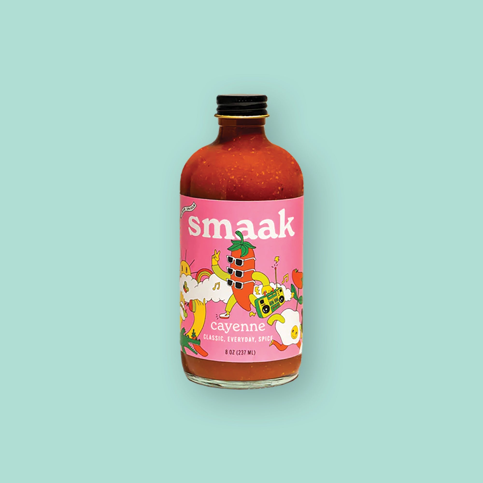 On a mint green background sits a jar. The clear jar has a black lid and a pink label. It is filled with reddith liquid mix. On the label is a colorful illustration of a jalapeno character with three sunglasses on and holding a radio. There are illustrations of clouds, sun, rainbow, musical notes and flowers. It says "smaak" in white, thick serif font. It also says "cayenne" in white, thick serif font and under that it says "CLASSIC, EVERYDAY, SPICE" in white, all caps block font. 8 oz (237 ml)