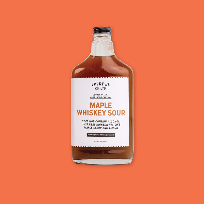 On an orangey-red background sits a jar. This COCKTAIL CRATE clear jar has a black lid and white label with brown syrup inside. It says "MAPLE WHISKEY SOUR" in a rust, all caps block font. It also says "DOES NOT CONTAIN ALCOHOL, JUST REAL INGREDIENTS LIKE MAPLE SYRUP AND LEMON" in black, all caps block italic font. In a black box it says "REFRIGERATE AFTER OPENING"  in white, all caps block font. 375 ML 12 FL OZ