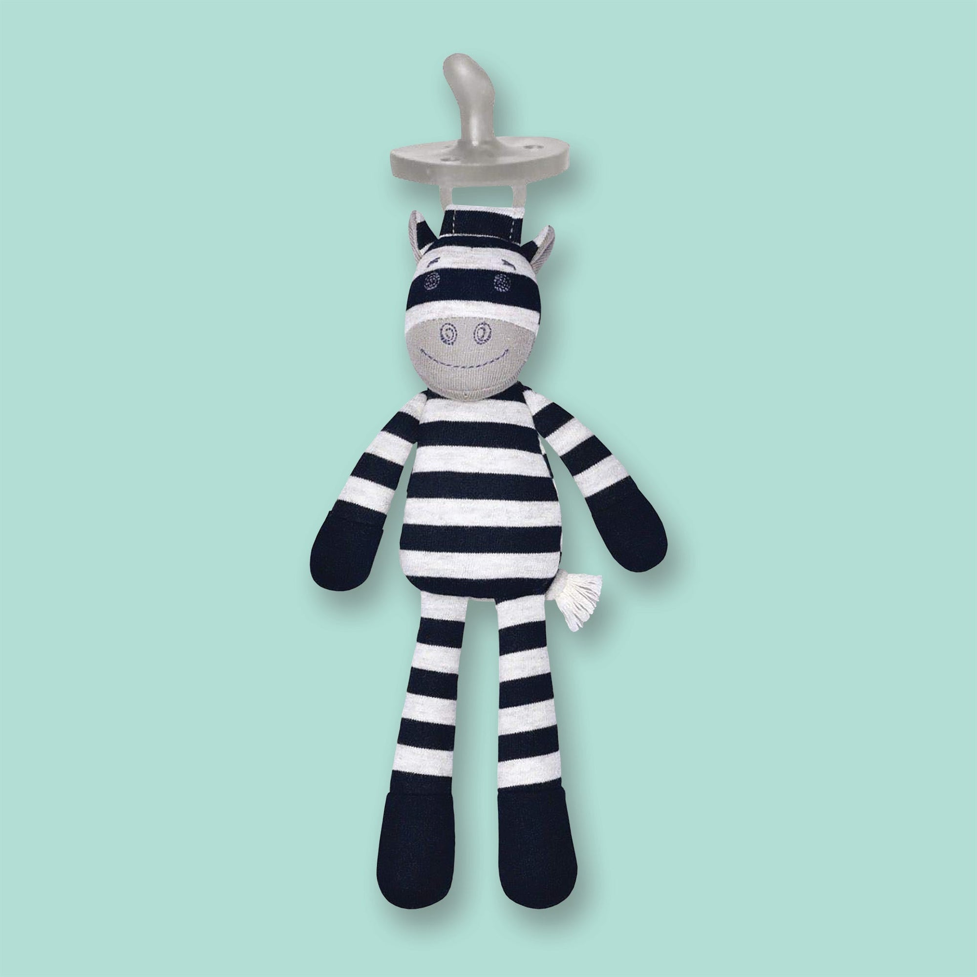 On a mint green background sits a black and grey snuggly buddy. It is an Organic Farms Buddies eco-friendly plush pacifier striped cow.