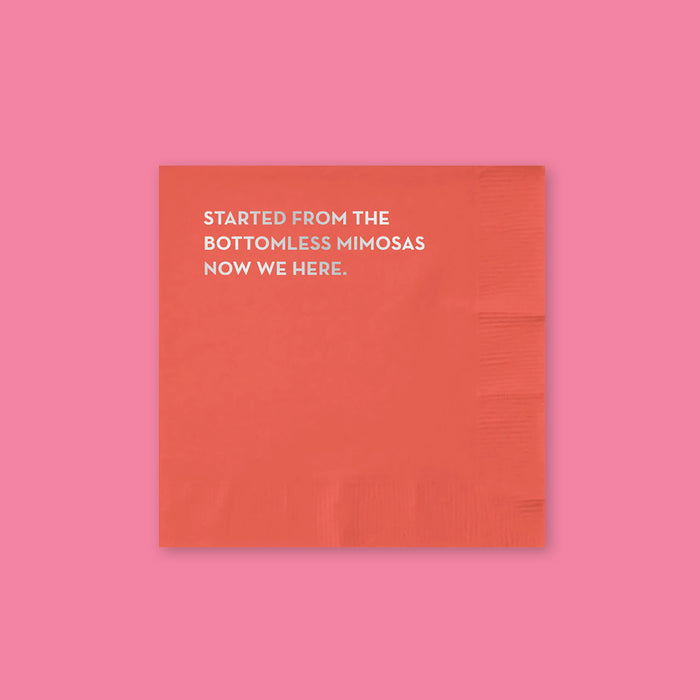 On a bubblegum pink background sits a napkin. This red napkins says "STARTED FROM THE BOTTOMLESS MIMOSAS NOW WE HERE." in silver, all caps block font.