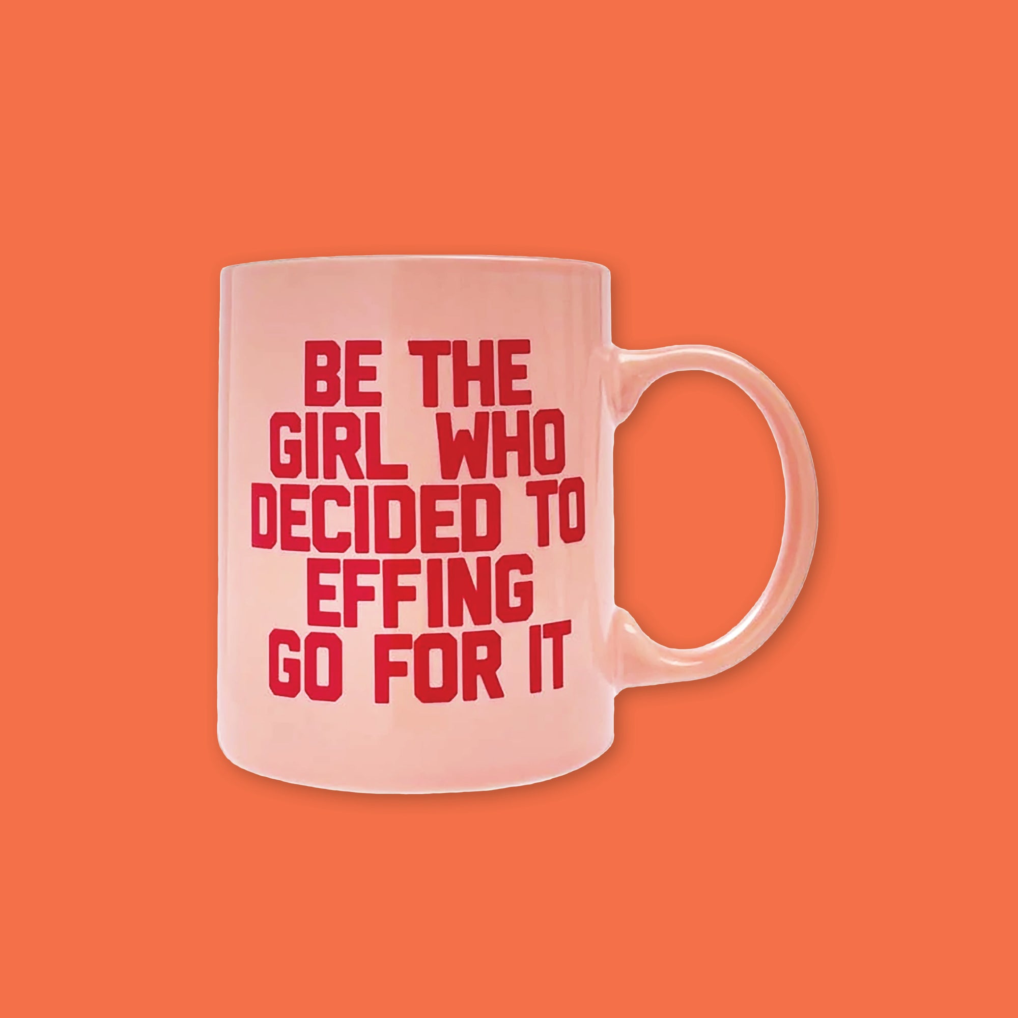On an orangey-red background is a photo of a pink diner mug. On the mug is red all-caps collegiate writing that says "Be the girl who decided to effing go for it." 