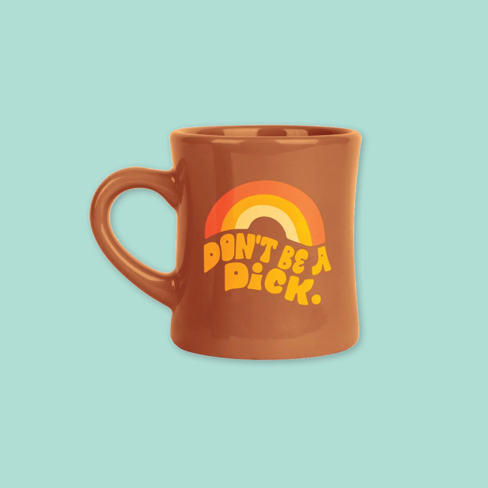 On a cool aqua background is a brown diner style mug with orange, groovy style font that says "Don't Be A Dick." with an orange, light orange and yellow rainbow above it.