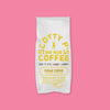 On a bubblegum pink background is a white bag of coffee. The coffee is Scotty P's Coffe Sugar Cookie Blend. It is a "warm, sweet, buttery treat." 12 oz (350g).