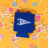 On a sunny mustard background sits a koozie with white crinkle and big, colorful confetti scattered around. The black koozie has blue koozie has a white handdrawn illustration of a pennant with handdrawn script font that says "Michigan."