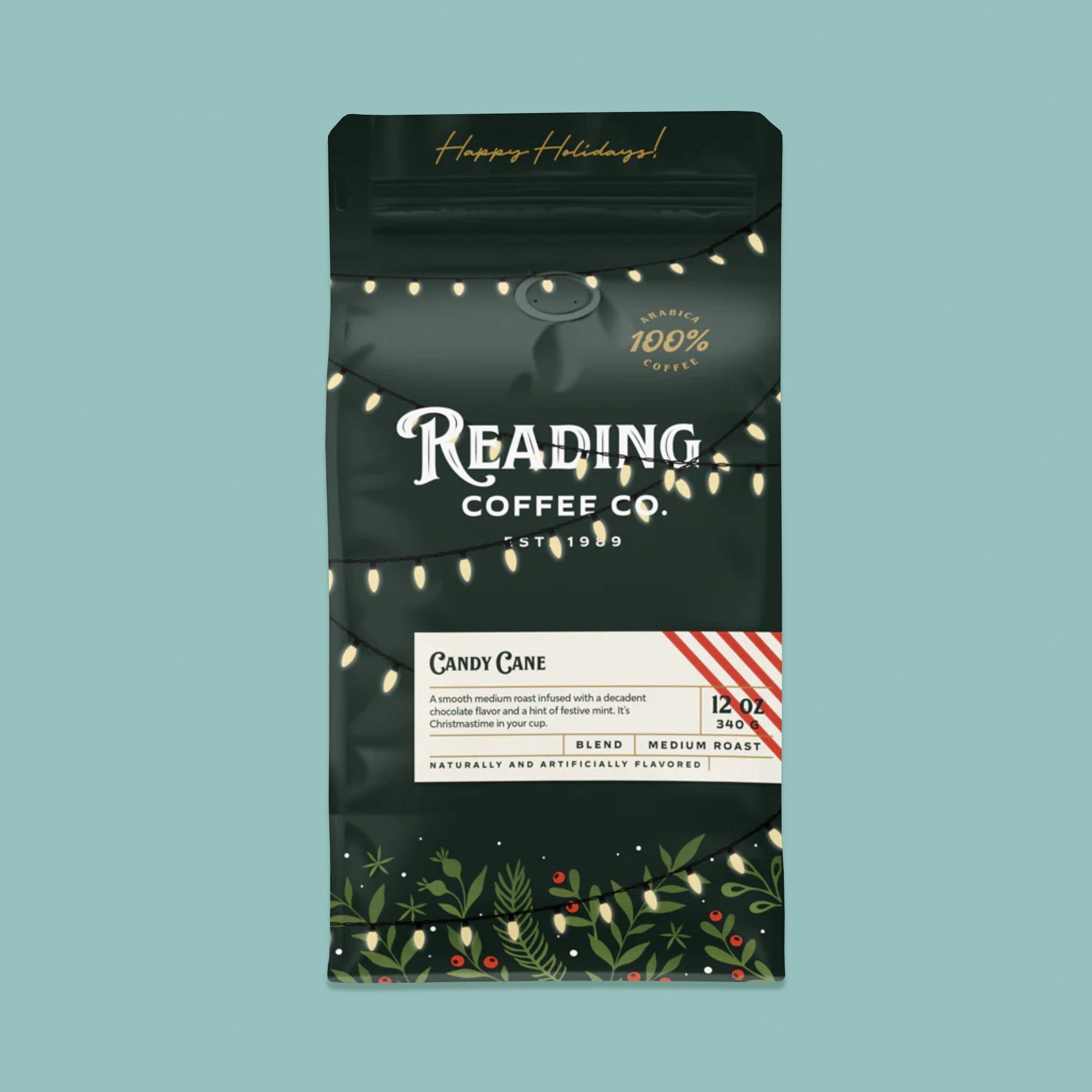 On a sage green background sits a dark green package of coffee. This package is gold, white, and dark green lettering. There are swags of lights and greenery with berries. It says "Happy Holidays!", "Reading Coffee Co. Est. 1989", "Candy Cane Coffee Blend Medium Roast." It is '100% Arabica Coffee. It also says "A smooth medium roast infused with a decadent chocolate flavor and a hint of festive mint. It's Christmastime in your cup." 12 oz 340g
