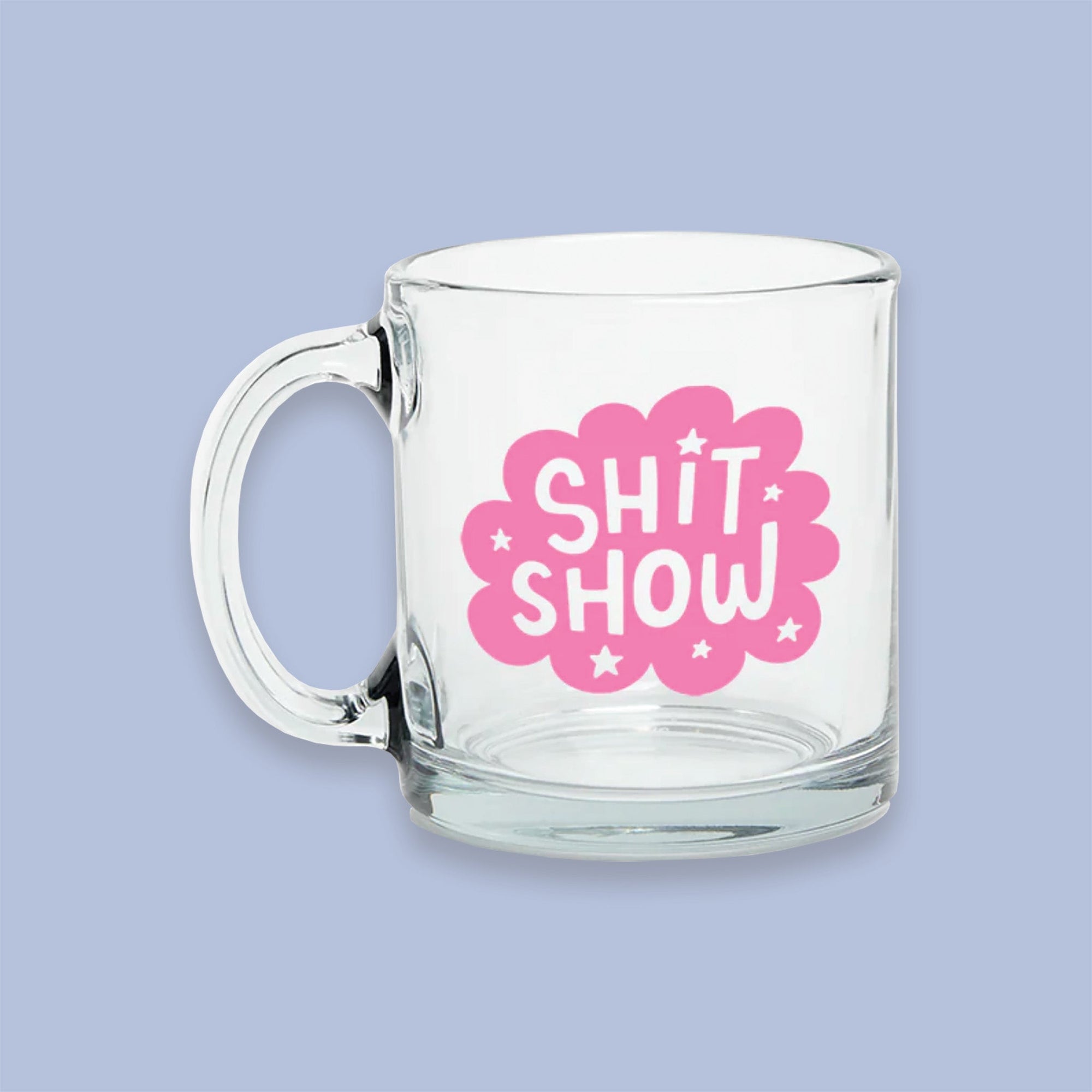 On a lavender background sits a mug. The clear glass mug has a bubblegum pink cloud on the front with white stars and it says "SHIT SHOW" in white, all caps handwritten lettering.