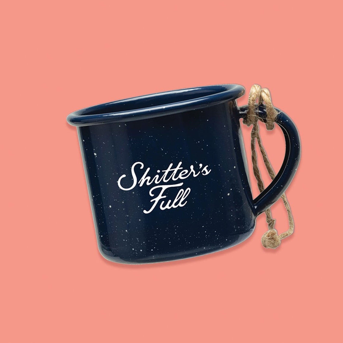 On a pink coral background sits a campfire mug. This Christmas Vacation inspired mug is navy with white specks and it says in white lettering "Shitter's Full." It has natural twine on the handle.