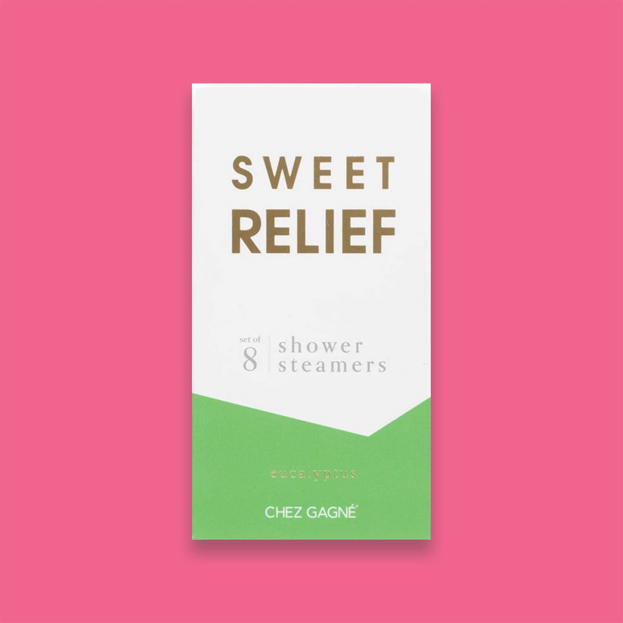 On a hot pink background sits a box. This picture is a close-up of a white and lime green package that says "SWEET RELIEF" in gold foil, all caps block lettering. Under it says "set of 8" and " shower steamers" in grey, lowercase serif font. At the bottom it says "eucalyptus" in gold foil, lower case serif font.