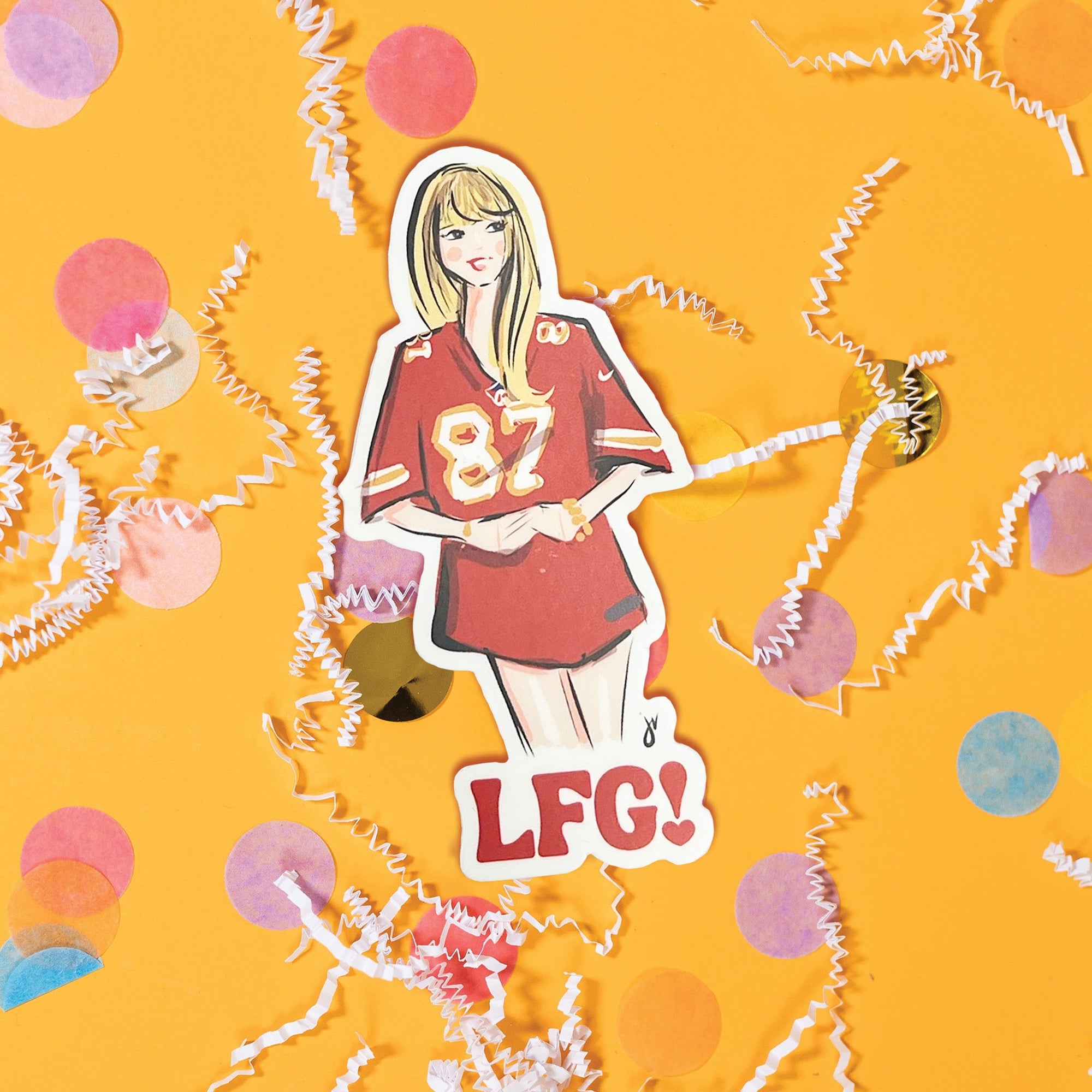 On a sunny mustard background sits a sticker with white crinkle and big, colorful confetti scattered around. This Taylor Swift inspired sticker is an illustration of Taylor Swift wearing a Kansa City Chiefs jersey with the number 87 on it. 