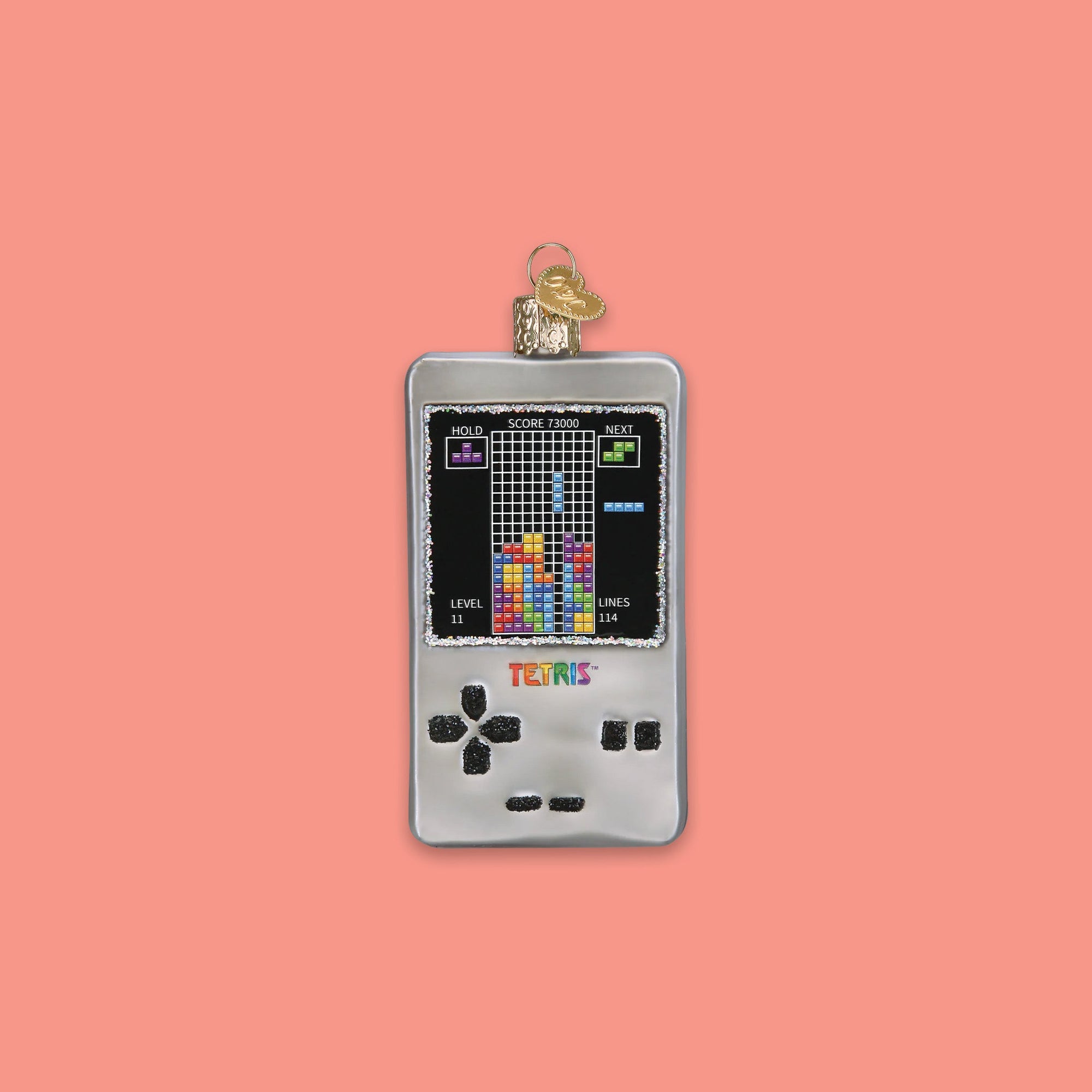 On a coral pink background sits a Tetris game glass ornament.
