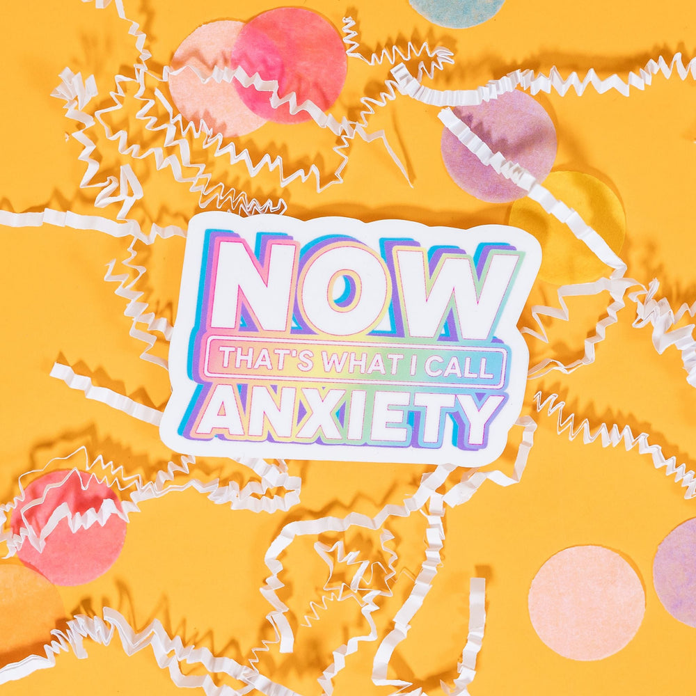 On a sunny mustard background sits a sticker with white crinkle and big, colorful confetti scattered around. This 90's-style white sticker says "Now That's What I Call Anxiety" in white block font with a colorful, pastel ombre color under it. 2"-3"