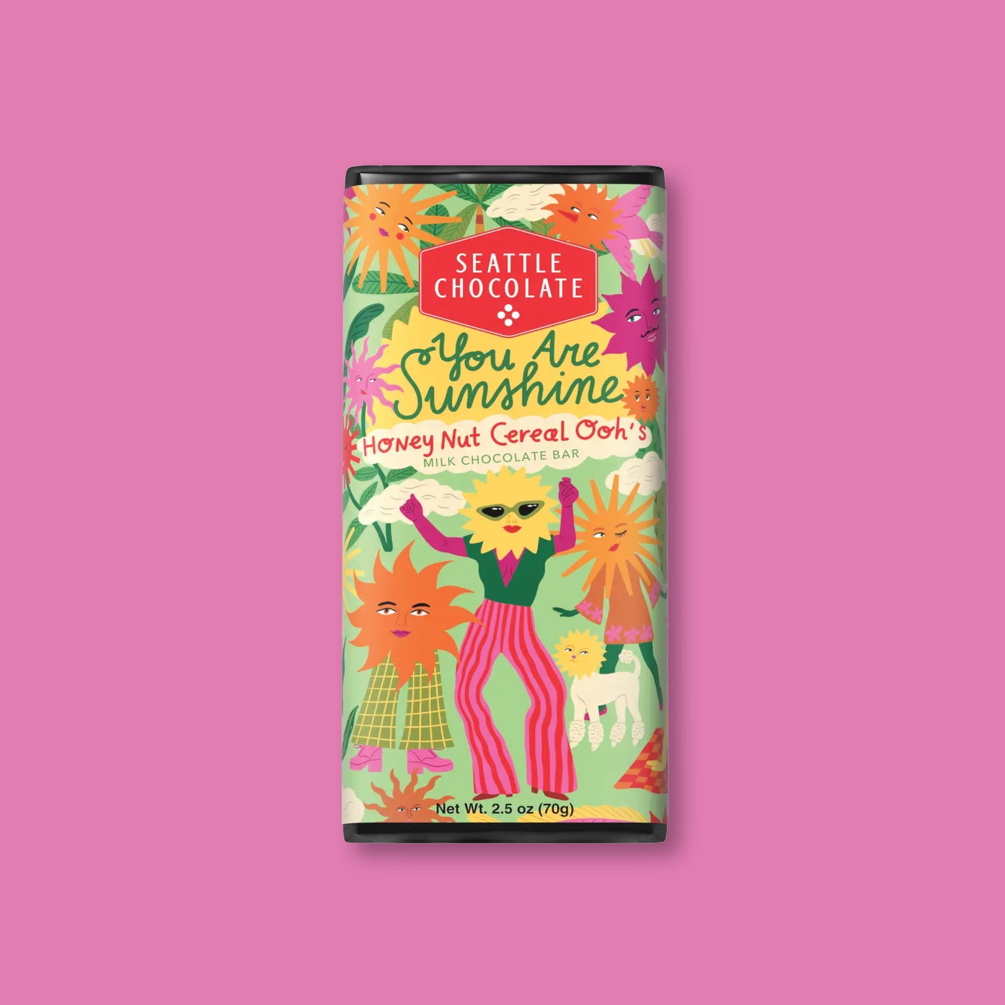 On a raspberry pink background sits a package. This SEATTLE CHOCOLATE has a colorful label and has illustrations of different colored suns with full bodies dancing. It says "You Are Sunshine", "Honey Nut Cereal Ooh's" in handwritten lettering. It is a MILK CHOCOLATE BAR. Net Wt. 2.5 oz (70g)